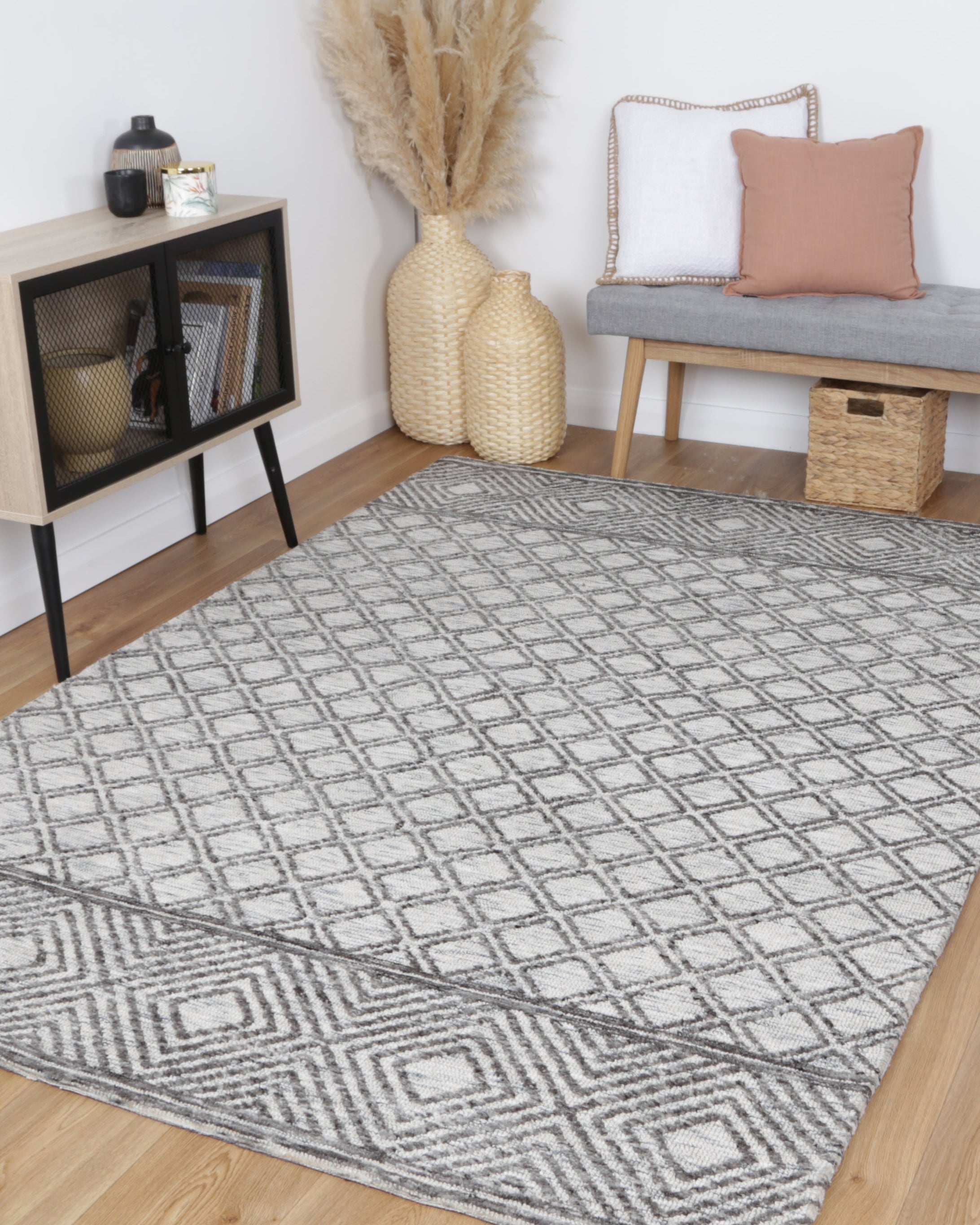 Alayah Diamond Trellis Grey & taupe Rug in living room with black side board and grey bench