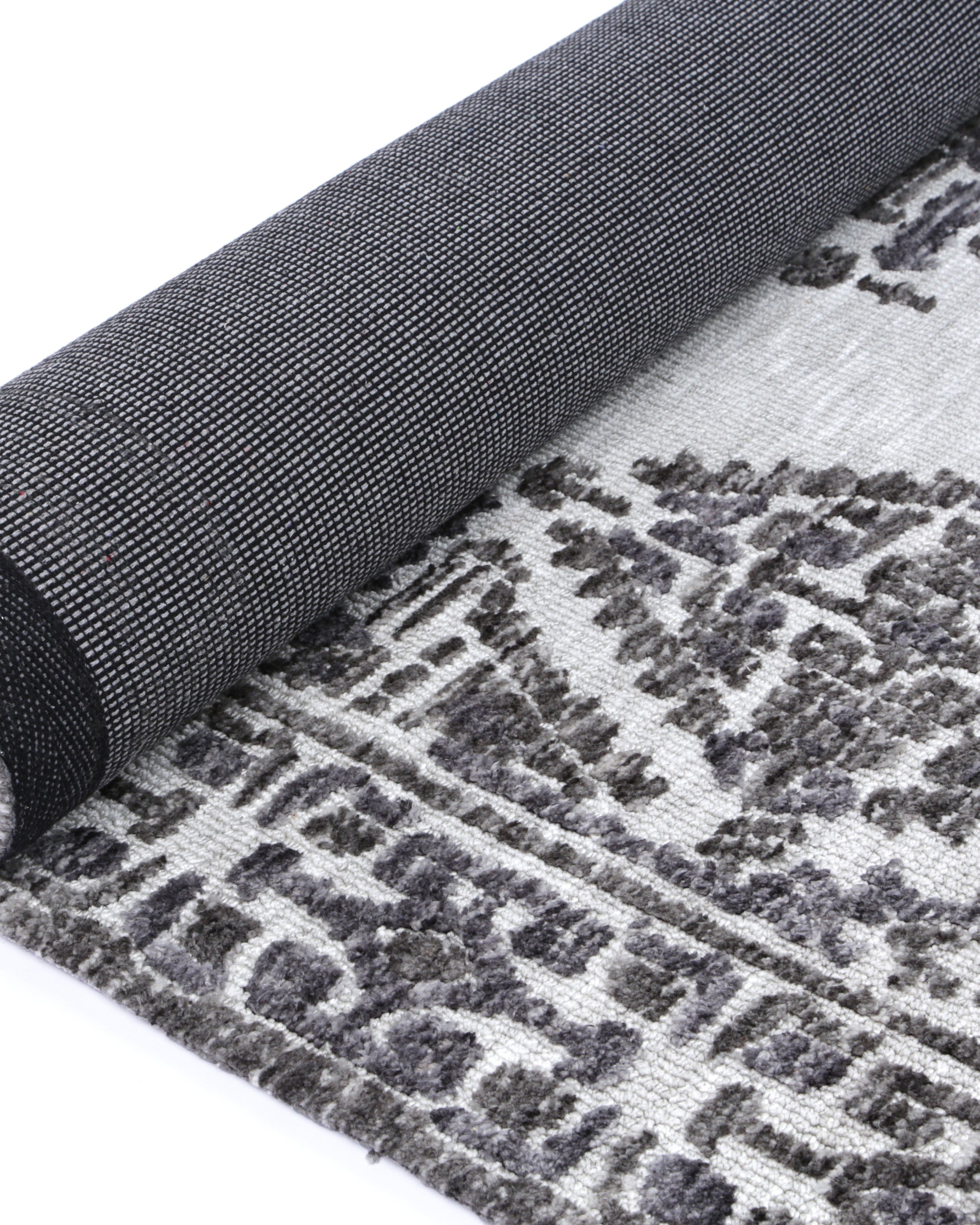 Alayah Ornamental silver Rug rolled with dark backing