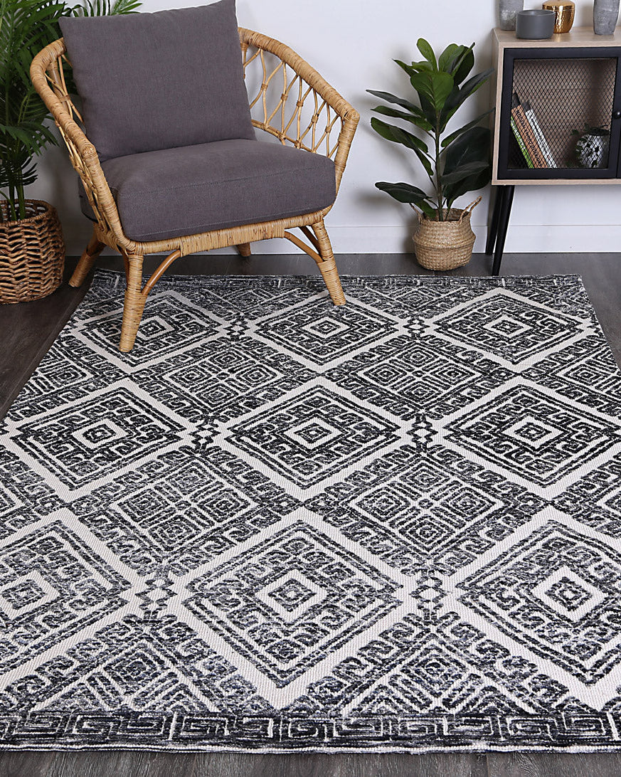 Alayah Diamond Grey Rug in living space with plants on grey floor boards