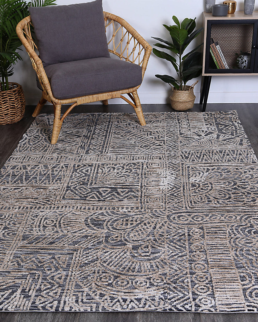 Alayah Charcoal Flower Rug in living space with grey chair on dark floors