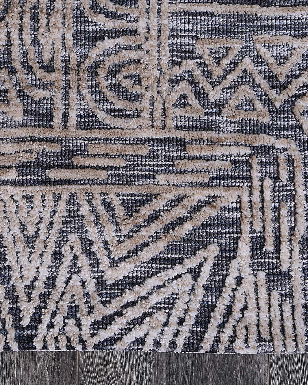 Alayah Charcoal Flower Rug corner photo on dark flooring