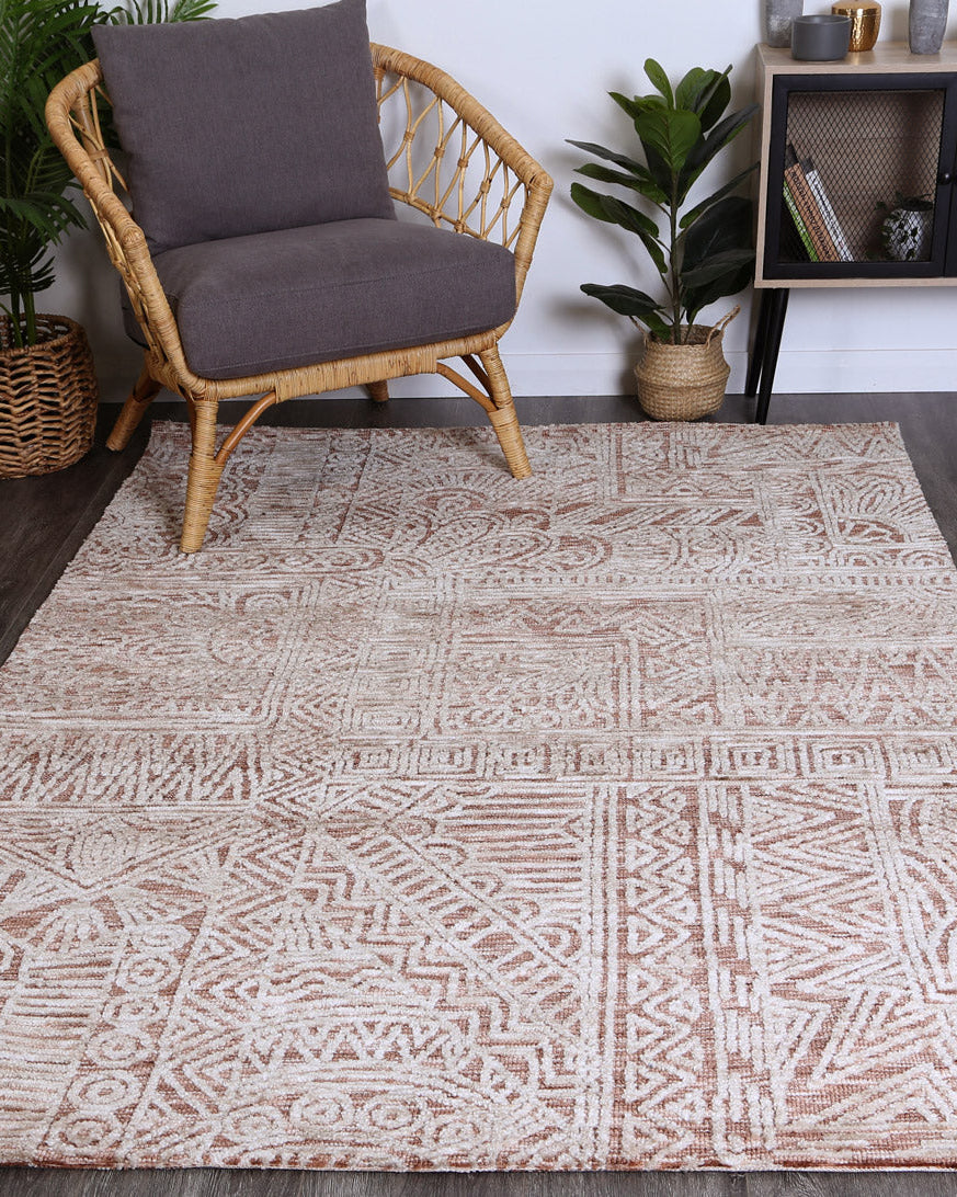 Alayah terracotta Flower Rug in living room with dark flooring and grey chair