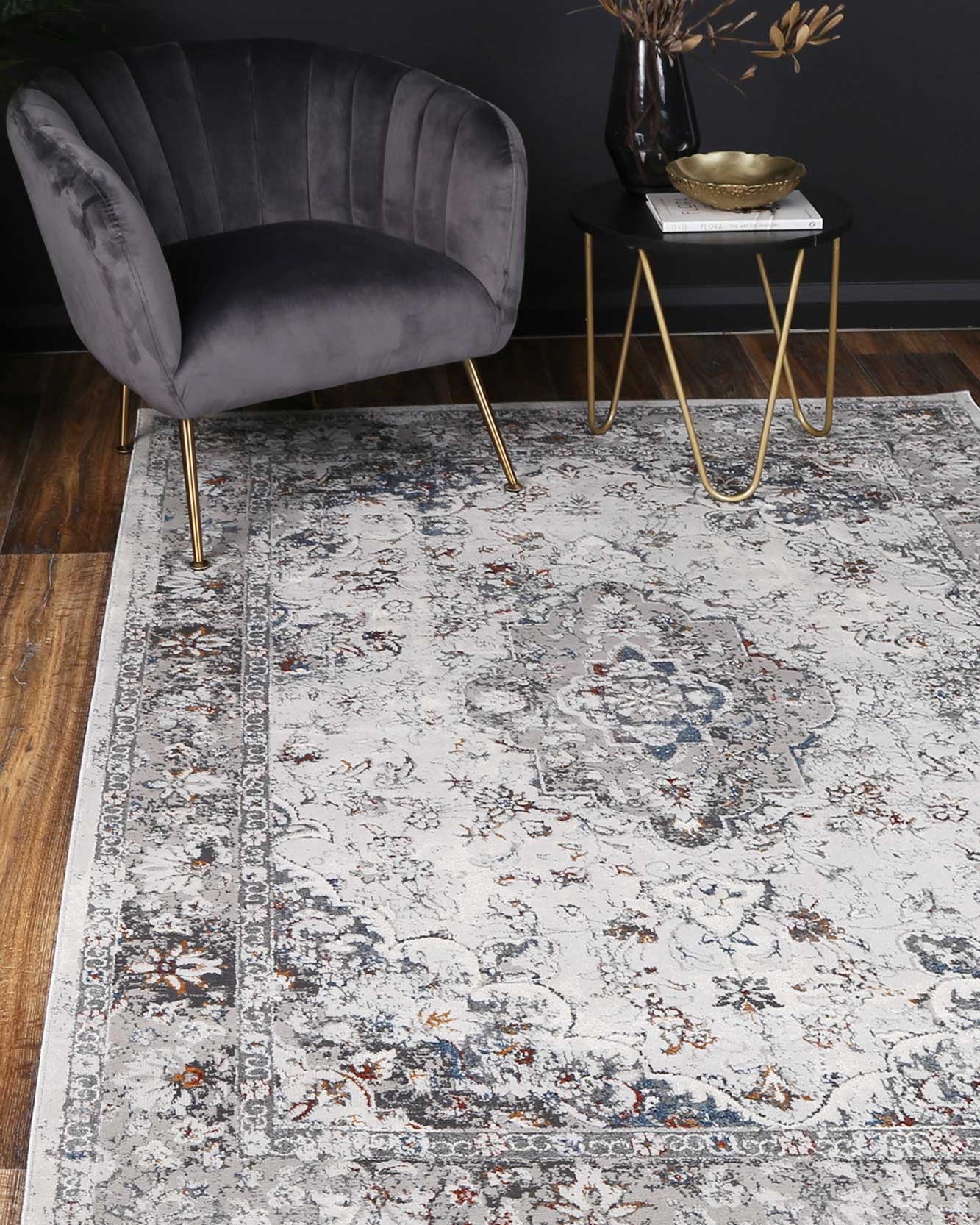 Almada ash and multicoloured Florwers transitional Rug with dark wooden flooring, black walls, velvet arm chair and warm metal acessories